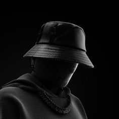 a black and white photo of a person wearing a hat with the hood pulled back