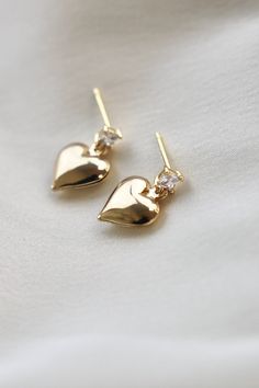 A square CZ stud with a dangling puff heart. Materials: gold pate square cz stud with sterling silver post, brass puff heart SKU: E1536G Heart Trend, Puffed Heart, Vintage Heart, Ear Jewelry, Staple Pieces, Jewelry Gift Box, Quality Jewelry, Everyday Essentials Products, Jewelry Gifts