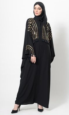 Featuring a kimono style flared abaya dress in nida fabric adorned with gold sequinned panels the all over the front bodice till the waist and sleeves. It is accentuated with thread fringes detail at the edges of sleeves and front embroidery. It has a loose silhouette perfect to be worn for evening wear ensemble.FIT : Relaxed fit.COMPOSITION : Nida.CARE : Dry clean only. Festive Long Sleeve Embellished Abaya, Eid Floor-length Sequined Kaftan, Gold Sequined Dresses For Eid, Gold Floor-length Abaya, Cape Abaya For Evening And Eid, Eid Party Abaya With Sequins, Eid Embellished Maxi Abaya, Party Abaya With Sequins For Eid, Sequin Abaya For Eid Party