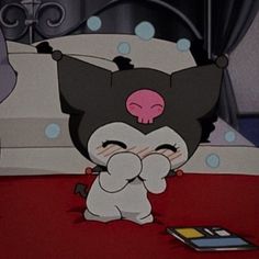 a cartoon character is sitting on the floor in front of a cell phone and looking at it