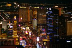 the las vegas skyline is lit up at night with neon signs and buildings in the background