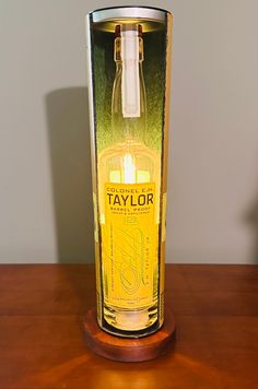 a bottle of taylor's yellow label sitting in a glass on a wooden table