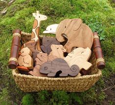 a basket filled with wooden animals on top of green grass