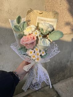 someone is holding a bouquet of flowers outside