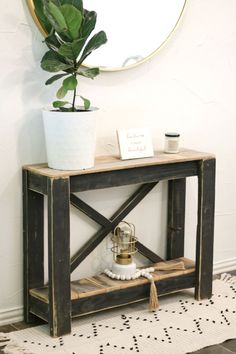 a potted plant sitting on top of a wooden shelf in front of a mirror