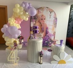 a table with balloons and decorations for a princess birthday party at the reception room in front of a backdrop