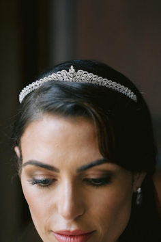 a woman wearing a tiara looking down at her cell phone