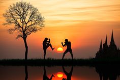 two people are dancing in front of a sunset with the sun setting behind them,