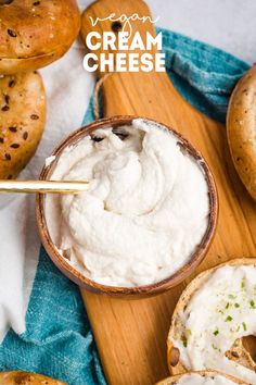 a wooden cutting board topped with bagels and cream cheese