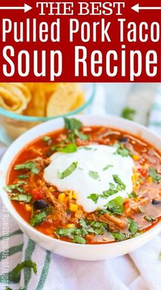 the best pulled pork taco soup recipe in a white bowl with sour cream on top