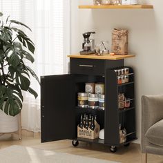 a kitchen cart with spices and condiments on it in front of a potted plant