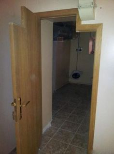 an open door leading to a bathroom with a toilet in the corner and tiled floor