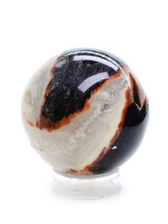 a black and white marble ball on a clear base with some red streaks around it