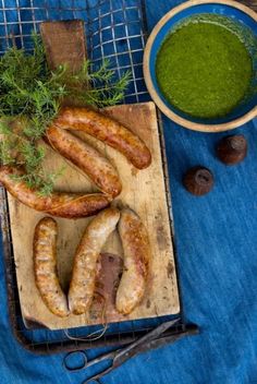 sausages on a cutting board with green sauce