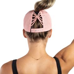 the back of a woman's head wearing a pink hat with a bow