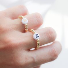 Beautiful beaded Ring with acrylic letters strung on an elastic cord. C U S T O M I N I T I A L ∙ R I N G ----------------------♡--------------------- M A T E R I A L S: * Ball: 18k Gold Plated over Brass * Beads gold: 3 mm * Letters: 7mm * It is made with stretchy elastic string that is very good quality!! -----------------------♡-------------------- SIZE * Adjustable Range US 6 - 8 - 9 ------------------------♡-------------------- H O W T O O R D E R 1.) Choose the Option in the drop down menu Trendy Round Jewelry With Letter Beads, Minimalist Jewelry With Letter Round Beads, Minimalist Jewelry With Round Letter Beads, Adjustable Personalized Midi Rings, Adjustable White Initial Ring As A Gift, Minimalist Letter Beads Jewelry For Friendship, Adjustable White Initial Ring Perfect For Gifts, Minimalist Personalized White Initial Ring, Adjustable Initial Ring