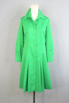 "Smart! This crisp green shirtdress is circa 1970s and can be worn as a sheath, or belted for a shirtwaist look. Pair it with a happy vintage scarf. It is in very good condition without holes or stains. Estimated size 14 40\" bust 36\" waist 44\" hip 42\" nape to hem Purveyor's Note: We have searched far and wide, wrestled bears, braved the cold, traversed mountain ranges, fought pirates, swam with sharks and eaten at many a questionable road side taco stand to provide our customers with one of Fitted Green Shirt Dress With Button Closure, Fitted Green Long Sleeve Shirt Dress, Green Fitted Long Sleeve Shirt Dress, Green Knee-length Shirt Dress With Button Closure, Formal Green Shirt Dress, Vintage Green Dress For Work, Green Fitted A-line Shirt Dress, Formal Green Long Sleeve Shirt Dress, Button-up Green Shirt Dress For Formal Occasions