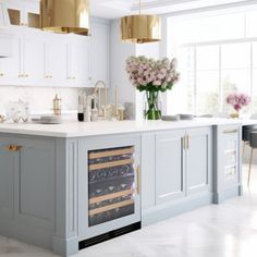 a kitchen with white cabinets and gold accents