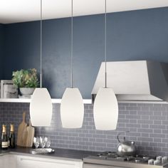 three lights hanging from the ceiling in a kitchen