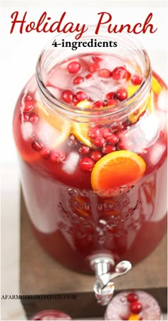 a glass jar filled with pomegranate and orange slices