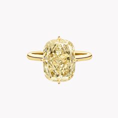 an oval cut yellow diamond ring on a white background with the center stone in gold