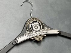 a metal hanger with a badge on it that says office engelhard and is attached to a wall