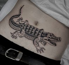 a black and white photo of a lizard tattoo on the side of a woman's stomach