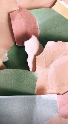 several pieces of paper that have been colored pink, green, yellow and orange with some torn off them