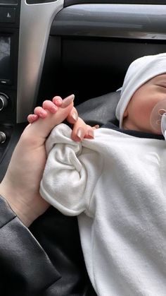 a woman holding a baby wrapped in a blanket