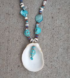 This is a blue & turquoise color beaded necklace, made with shells, pearl, acrylic, and glass beads.  The skulls on the necklace are made out of stone.  Inspired by spiritual ceremonies the holistic effects of this necklace provides protection from outside sources, along with balancing and aligning all chakras, stabilizing mood, and instilling an inner calm.  Necklace Measurements:  Length: 24" Pendant Height: 2.5" Pendant Width: 2" If you have any questions or would like to see additional pictu Artisan Turquoise Beaded Necklace For Beach, Bohemian Blue Shell Necklace For Jewelry Making, Unique Beaded Turquoise Necklace For Beach, Blue Shell Beaded Necklaces With Round Beads, Unique Turquoise Beaded Necklaces For Beach, Spiritual Polished Beads Necklace For Beach, Turquoise Necklace With Large Beads For Beach, Spiritual Beach Jewelry With Polished Beads, Spiritual Polished Beads Jewelry For Beach