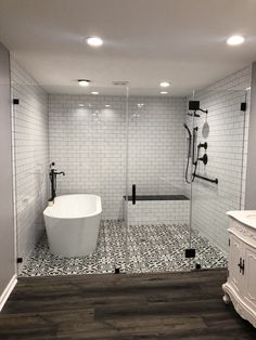 a white bath tub sitting next to a walk in shower