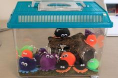 a plastic container filled with lots of different colored stuffed animals sitting on top of a table