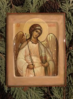 an icon of the angel holding a cross in front of pine cones and fir tree branches