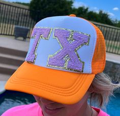 Step out in style with this eye-catching Orange Hat and Purple Texas TX Chenille Patch Hat. This baseball cap trucker style combines classic comfort with bold design, featuring a vibrant orange base and a standout purple chenille patch that showcases the iconic shape of Texas. The mesh back ensures breathability, making it perfect for those sunny days out or casual hangouts. Whether you're showing off your state pride or just love the color combo, this hat is a versatile addition to any wardrobe Orange Trucker Baseball Cap One Size, Orange Trucker Snapback Hat, Orange Curved Brim Trucker Hat, Orange Trucker Hat, One Size Fits Most, Orange Trucker Hat For Sports, Orange Trucker Hat One Size, Orange Trucker Hat With Curved Brim, Orange Baseball Cap For Sports Events, Orange Adjustable Trucker Hat With Curved Bill