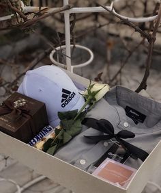 a hat, shirt and other items are sitting in a box on a table outside