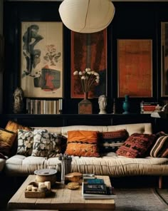 a living room filled with lots of furniture and books on top of a wooden table