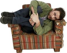 a man laying on top of a chair with his legs crossed