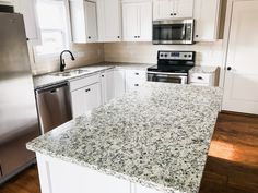 an empty kitchen with granite counter tops and stainless steel appliances