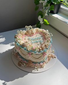 a heart shaped cake sitting on top of a table next to a potted plant