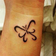 a small tattoo on the wrist of a woman with a butterfly in it's center