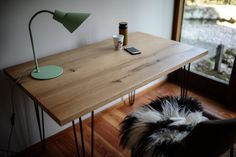 a wooden table with hairpin legs and a phone on it