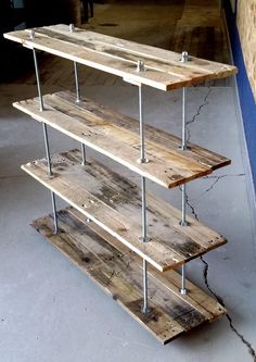 three tiered wooden shelf sitting on top of a cement floor