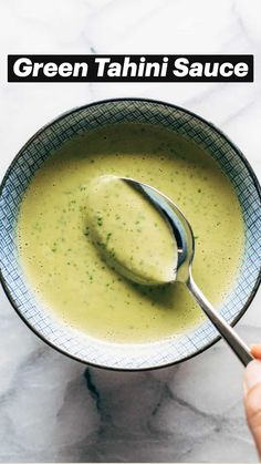 a hand holding a spoon over a bowl of green tahini sauce with the title above it