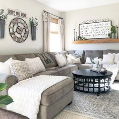 a living room filled with lots of furniture and pillows on top of a rug in front of a window