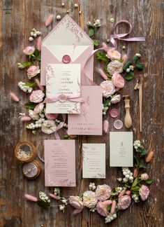 the wedding stationery is laid out with flowers and ribbons