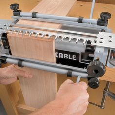 a man working on a table sawing machine with the word cable attached to it