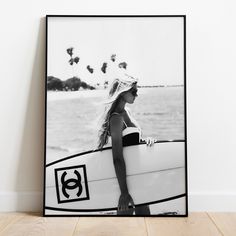 a black and white photo of a woman holding a surfboard