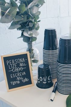 black and white striped cups on a table with a chalkboard sign next to them