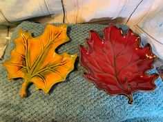 two leaf shaped dishes sitting on top of a blue towel