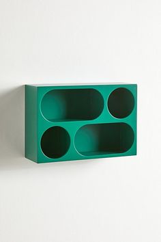 a green shelf with three holes in it